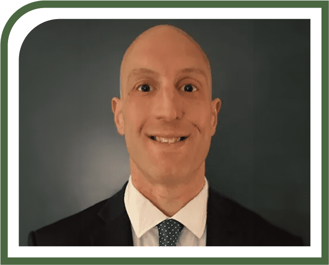 A man in suit and tie smiling for the camera.